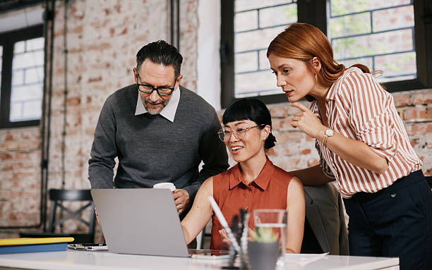 istock Adult Professionals Collaborating In Modern Office With Laptop, Coffee, And Documents, Focused, Supportive Mood, Together 2239246353