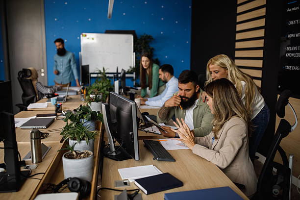 istock Team of colleagues collaborates in a modern office, planning a project at a shared desk 2239248390