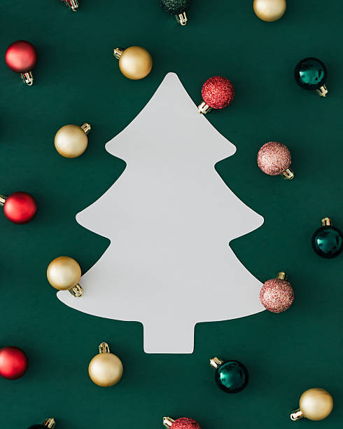 istock Creative colorful Christmas baubles decoration pattern on green background with Xmas tree paper card note copy space. Minimal Christmas and New Year concept. Holiday festive background idea. 2239249768