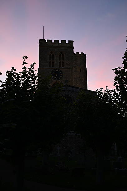 The church tower of St Mary the Virgin, Thame, backlit by a sunset sky
