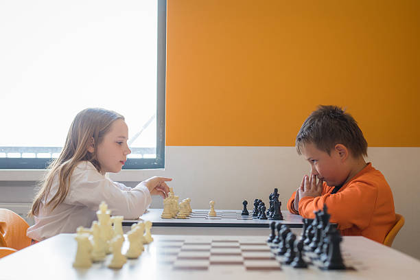 istock Concentrated children school student playing chess in classroom at school 2239265876