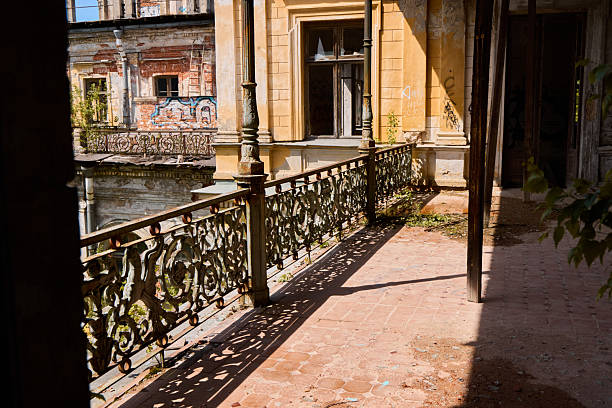An abandoned balcony that showcases intricate and detailed ironwork and its fading beauty, filled with nostalgia