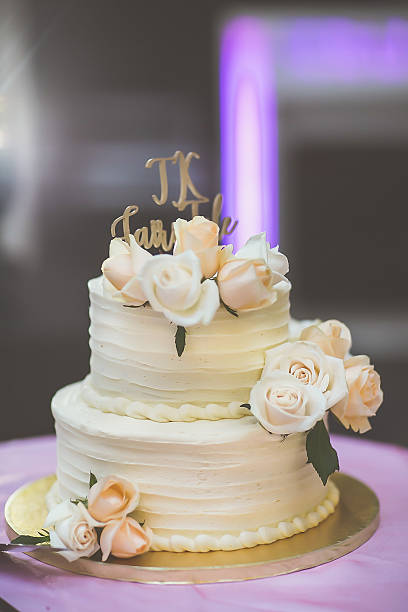 istock Beautiful white wedding cake decorated with flowers close up 2239273937