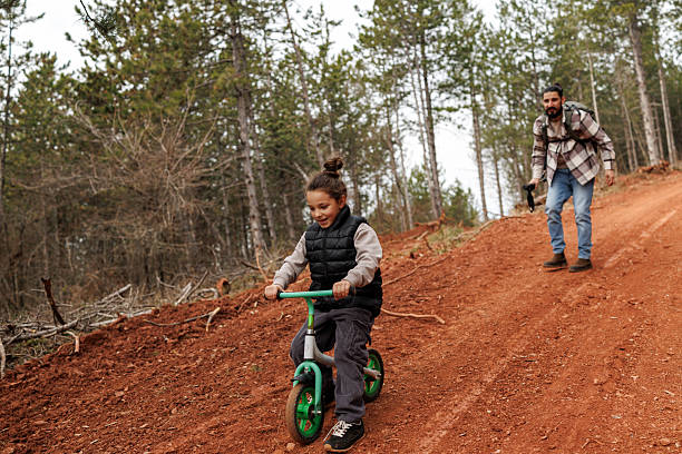 istock Devoted father teaching his son to ride bicycle in nature 2239279552