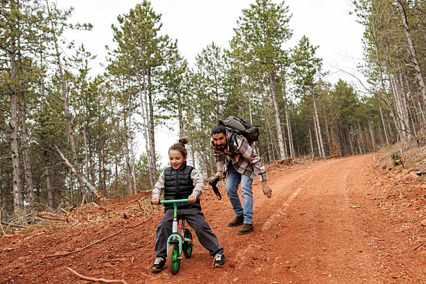 istock Devoted father teaching his son to ride bicycle in nature 2239279616