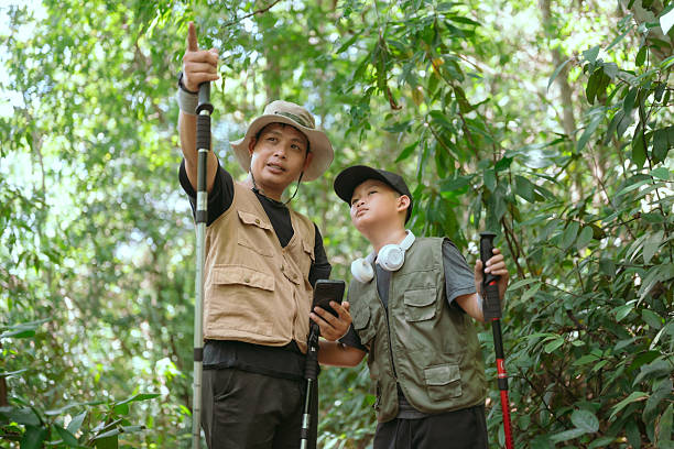 istock Men exploring nature in a tropical forest while guiding a young boy on an educational adventure 2239291322