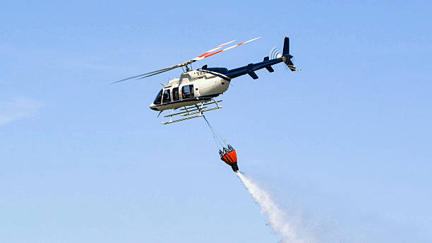 istock Firefighter helicopter simulating extinguishing forest fires by spraying water in mid-flight. 2239293049
