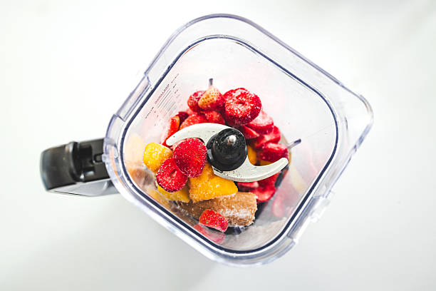 istock Frozen Fruit Smoothie Prep in Blender Top View with strawberries mango banana 2239294750