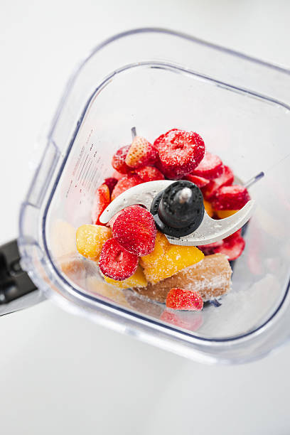 istock Frozen Fruit Smoothie Prep in Blender Top View with strawberries mango banana 2239294792
