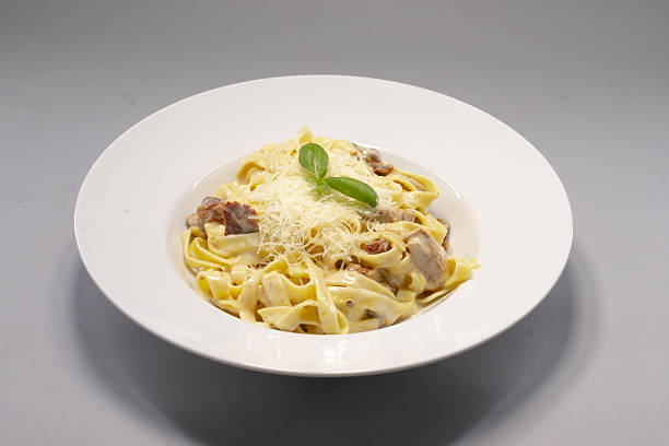 A delightful plate of Fettuccine Pasta generously topped with Cheese and Basil
