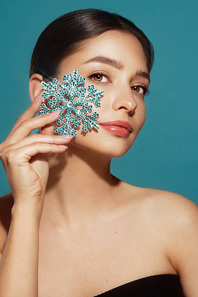 istock Beautiful young woman with glowing snowflake 2239298526
