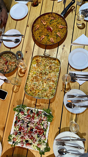Moroccan inspired dinner spread with paella and salad on wooden table