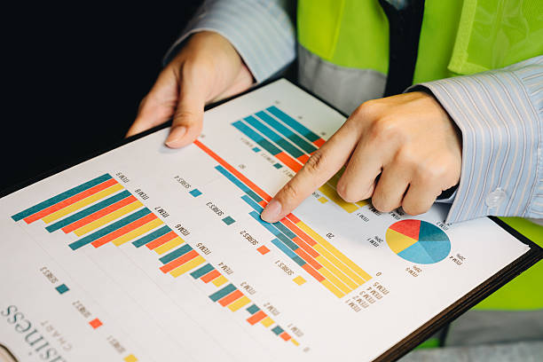 istock Business Professional Analyzing Colorful Bar Graphs and Pie Charts on Clipboard at Workplace during Meeting 2239308253