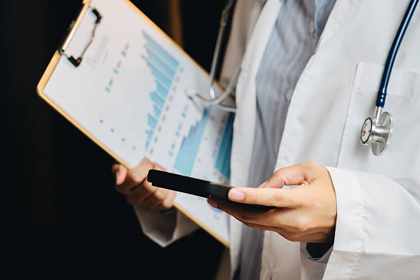 istock Medical professional analyzing data on smartphone while holding clipboard with charts and graphs in office setting 2239308419