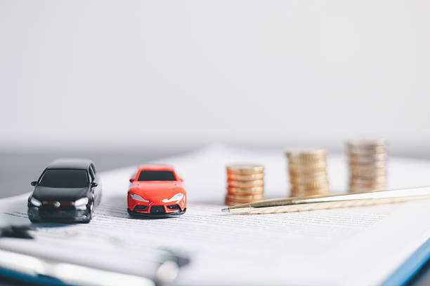 istock Red and black car models with open doors positioned beside stacked coins, symbolizing car loan, auto finance, insurance, investment, wealth, savings and money management concept. 2239309905