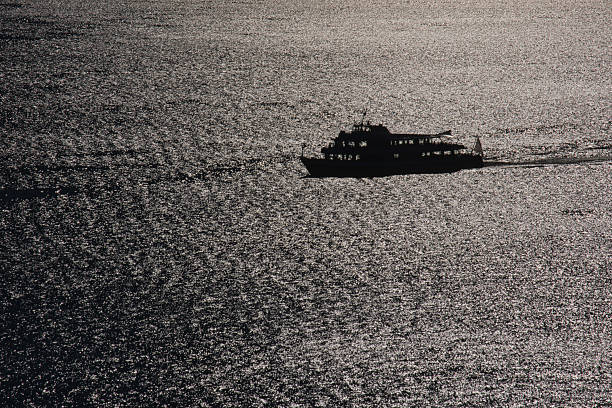 Bodensee, Schiff im Gegenlicht auf glitzerndem Wasser
