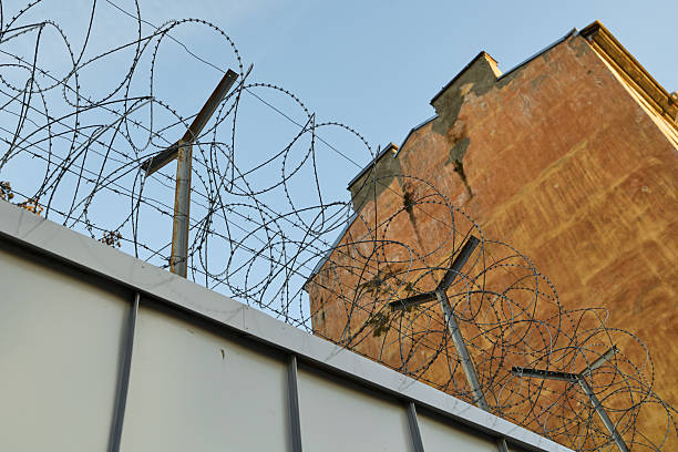 istock A Barbed Wire Fence is Surrounding a Tall and Imposing Brick Structure for security purposes 2239315682