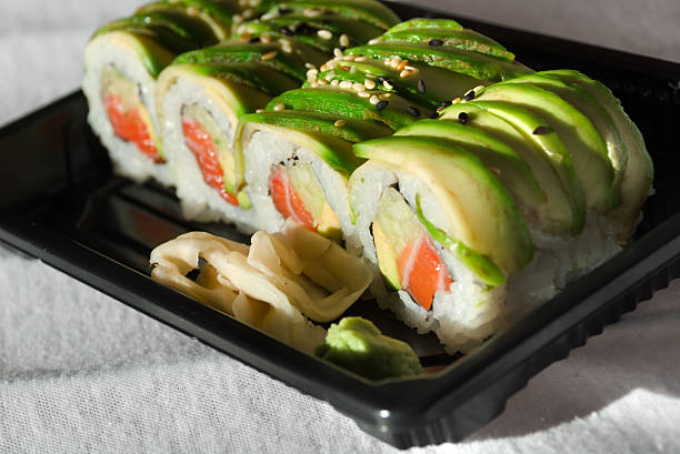 Sushi rice roll wrapped in a wooden plate.