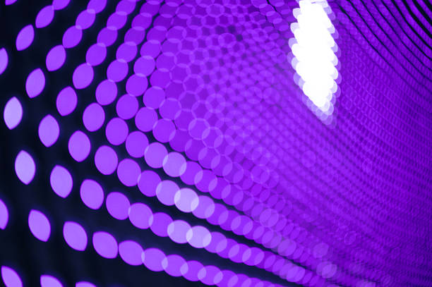 Garland lights with a blurred bokeh effect. Festive purple decorative lighting in a perspective concept. Background texture with LED lighting.
