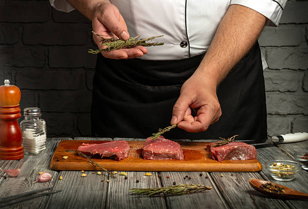 istock A chef is seasoning fresh beef steaks with herbs in a rustic kitchen. The wooden cutting board holds the meat, while spices and seasonings surround the scene, highlighting culinary preparation 2239325437