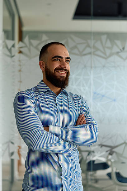 istock Man smiling with crossed arms in modern office 2239329268