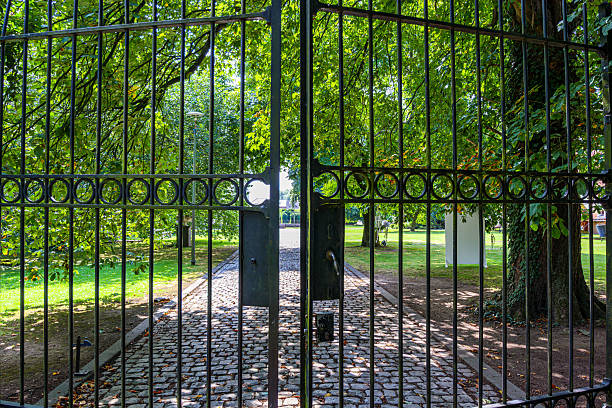 istock Close-up of bars of half-open black wrought iron gate 2239330342