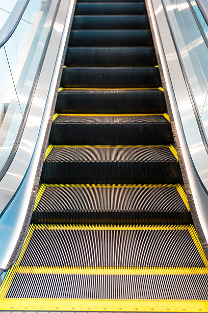 istock Premium escalator with metal steps and yellow safety lines modern architecture. 2239333367
