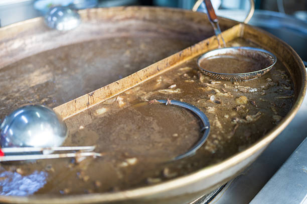 traditional hungarian goulash is boiling in a cauldron.