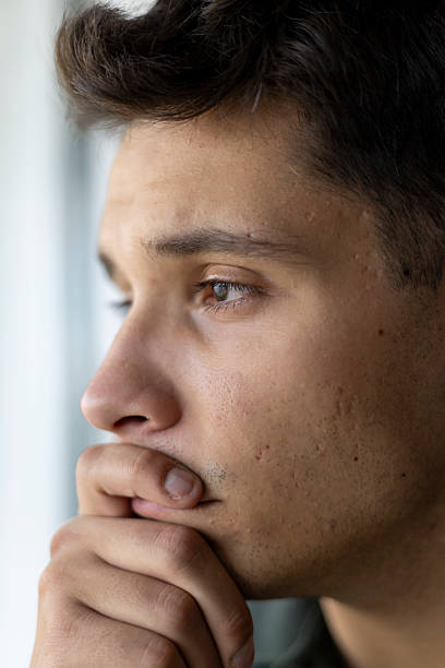 istock Young man thinking with hand on chin, feeling concerned and pensive 2239333933