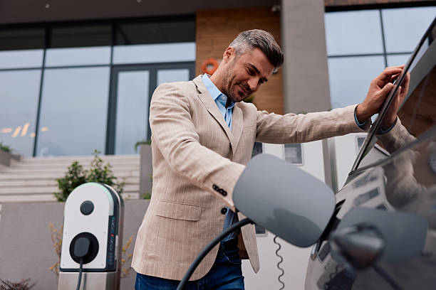 istock Man charging electric car at public station 2239334703