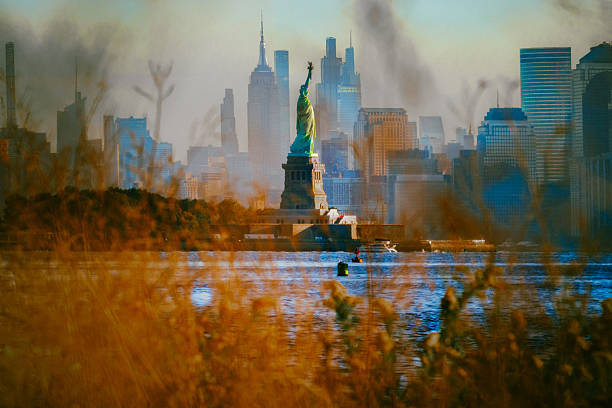 New York City's skyline from the Northern New Jersey marshlands. The Empire State Building and Statue of Liberty can be seen.