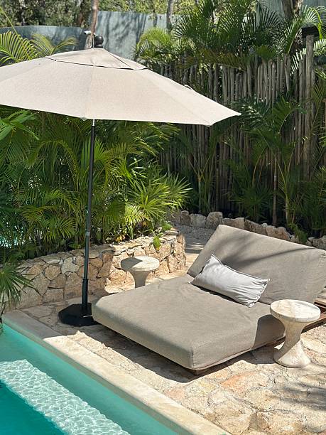 istock Lounge chair with umbrella by the pool 2239339639