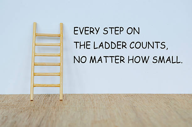 istock EVERY STEP ON THE LADDER COUNTS, NO MATER HOW SMALL text on white cover background with a wooden ladder representing perseverance and gradual progress. 2239344331