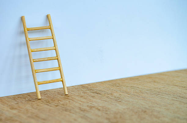 istock A single wooden ladder standing tall against a white cover with customizable space for text or ideas. 2239344350