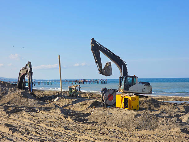 istock Yellow color excavator digging on the beach with ocean, full frame horizontal composition with copy space. 2239348775