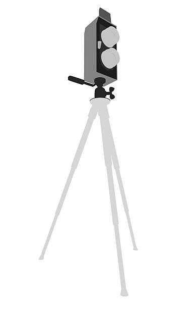 istock A black and white silhouette of a video camera on a tripod, centered against a plain white background. The tripod legs extend outward from the camera base. 2239355006