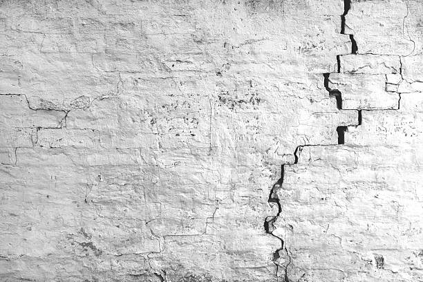 Cracked and damaged old brick wall with visible wear and texture. Worn urban pattern,