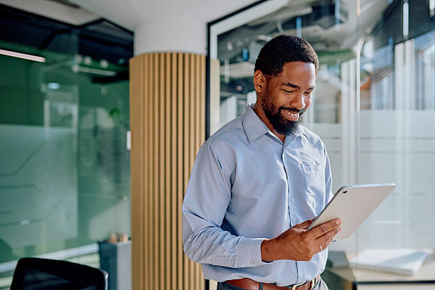 istock Businessman smiling and using digital tablet in modern office 2239358267