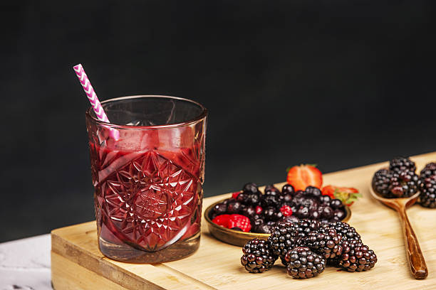 Red berry detox juice in cut crystal glass with straw