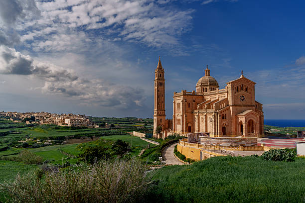 istock Sunlit Basilica and Bell Tower over Verdant Valleys under Blue Sky 2239366577