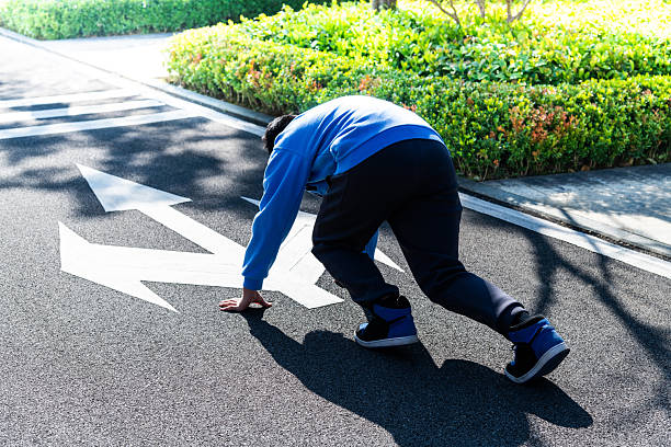 Teenager boy preparing for a race with three different direction arrow