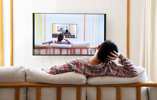 Teenage boy watching tv at home with same image in frame. The photos on the TV were also taken by me