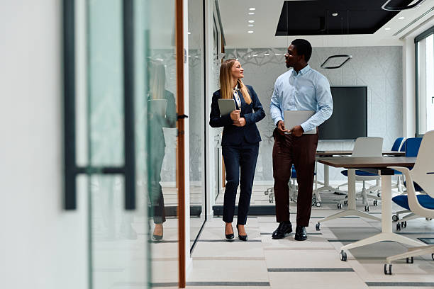 istock Business colleagues walking and conversing in modern office 2239372533
