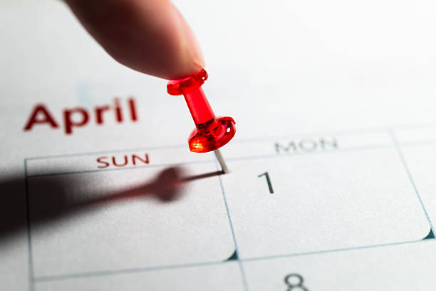 Human hand pushing pin on April 1, Fools' Day on calendar