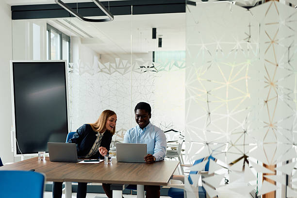 istock Diverse colleagues collaborating around laptop in modern office meeting 2239372930