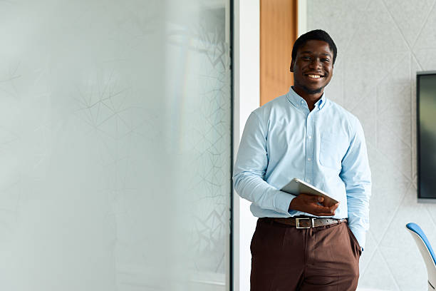 istock African man smiling, holding tablet in modern office 2239373031