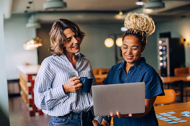 istock Two women discussing work while looking at a laptop in a casual setting 2239382748