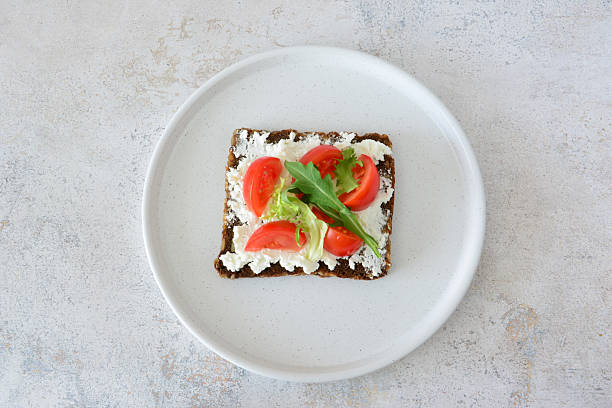 istock Delicious Open-Faced Sandwich with Fresh Tomatoes, cream cheese and Greens 2239384773