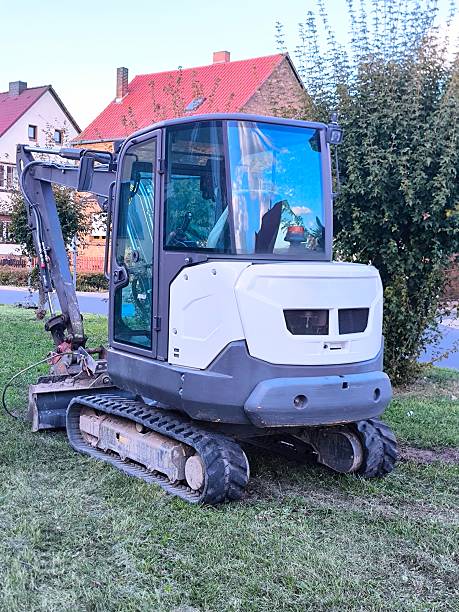 istock A compact mini excavator is parked on the grass in a residential area. 2239386885