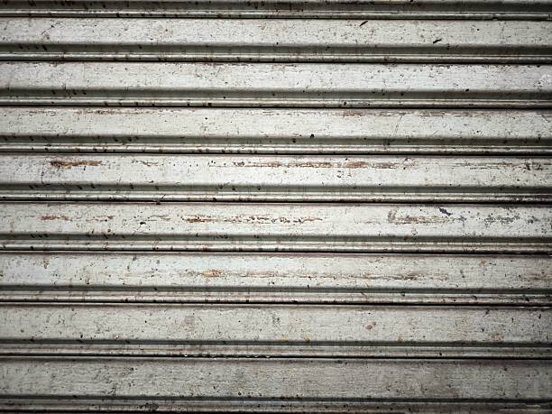 istock Texture of an old metal rolling shutter door. Backgrounds, textures, or design elements related to urban decay, construction, or street photography themes 2239398042